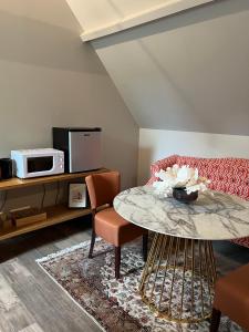 a living room with a table and a couch at Le Domaine des Bois in Blangy-le-Château