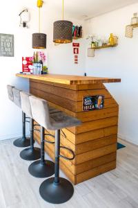 a wooden bar with two stools in front of it at Green Charm House Lisbon in Lisbon