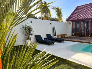 a backyard with a swimming pool and a villa at Moana Villa & Suites Bingin in Uluwatu