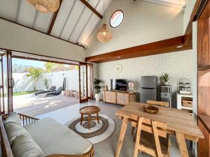 uma cozinha e sala de estar com uma mesa de madeira em Moana Villa & Suites Bingin em Uluwatu