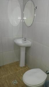 een badkamer met een wastafel, een toilet en een spiegel bij Parque Hotel in Rio de Janeiro