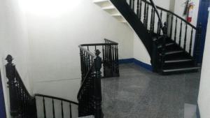 a staircase with black railings in a white room at Parque Hotel in Rio de Janeiro