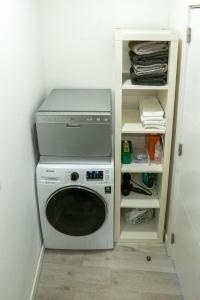 Waschmaschine und Trockner in einer Waschküche in der Unterkunft Green Charm House Lisbon in Lissabon