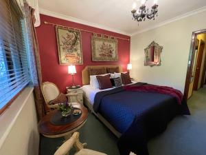 a bedroom with a bed and a table and a window at Rosewood Guesthouse in Margaret River Town