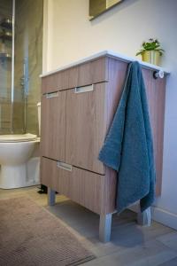 a bathroom with a wooden dresser with a blue towel at Green Charm House Lisbon in Lisbon