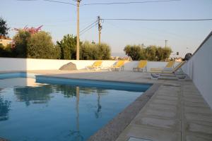 - une piscine avec des chaises jaunes à côté d'une maison dans l'établissement JP HOUSE, à Nelas