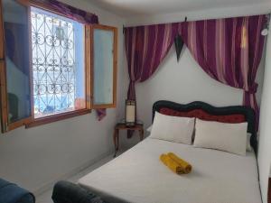 um quarto com uma cama com um objecto de madeira em Dar layla moulati em Chefchaouen