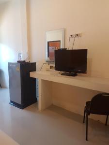 a desk with a television and a refrigerator in a room at Life&Love Resort in Ban Khlong Son
