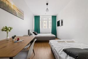 a room with two beds and a table and a dining room at Bright Residences in Tallinn Center by EasyRentals in Tallinn