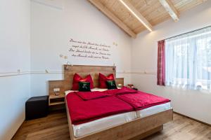 a bedroom with a large bed with red sheets and red pillows at Ferienwohnung Ronja 