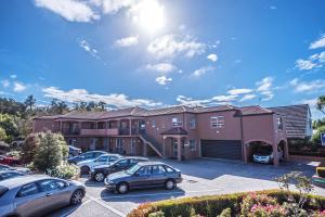 a building with cars parked in a parking lot at Kings Of Riccarton Motel in Christchurch