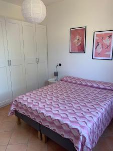 um quarto com uma cama grande e um cobertor roxo em A Casa di Nonna em Bosa