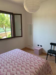 博薩的住宿－A Casa di Nonna，一间卧室设有一张床、一个窗口和一把椅子