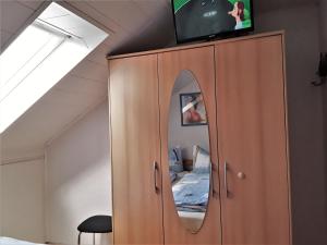 una camera da letto con TV sopra un armadio di Fewo Rasche zum Träumen a Beverungen