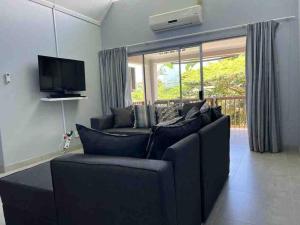 uma sala de estar com um sofá preto e uma televisão em Chaval Cove , 3 bedroom 2 Bathroom in St Lucia The bridge em St. Lucia