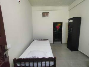 a small bedroom with a bed in a room at Jinnens Tourist Home in Ponnāni