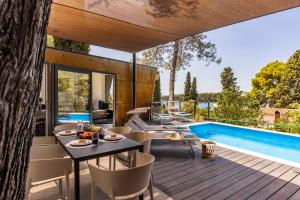 an outdoor patio with a table and chairs and a swimming pool at Porton Nature Hideouts in Rovinj +34 photos