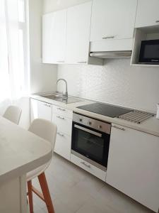 a kitchen with white cabinets and a stove top oven at AREAS NEGRAS- Apartamento centro de Cedeira. in Cedeira