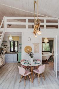 a kitchen and dining room with a table and chairs at Wiejskie Swawole-domki w lesie na wsi 