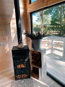 una estufa de leña en una cabaña con ventana en Wiejskie Swawole-domki w lesie na wsi, 