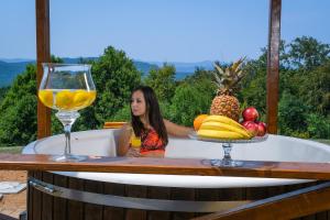 a woman sitting in a bath tub with a glass of wine at Vila Promaja in Kladovo