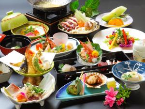 un montón de platos de comida en una mesa en Hozanso Beppu en Beppu