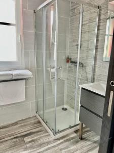 Plage à 50m Appartement Rêves de mer Villa Les Bains de Mers في مير-لي-بان: دش زجاجي في حمام به حوض غسيل