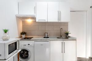 a white kitchen with a washing machine and a sink at Los Pocillos in Los Pocillos