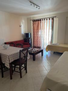 a living room with a table and a red couch at Dais Apartments in Mitika