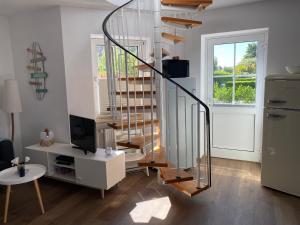 a spiral staircase in a living room with a television at Ferienwohnung Gustav - Moderne Maisonette-Wohnung mit Terrasse in Wangerooge