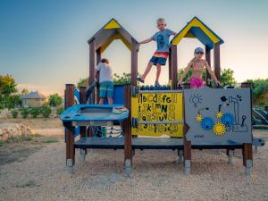 a group of three kids playing on a playground at Terra Park Phalaris in Novalja