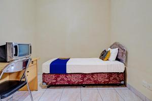 una piccola camera con letto e TV di SPOT ON 91482 Sentosa Home a Bandung
