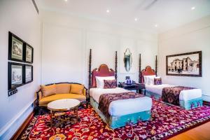 two beds in a room with a red rug at MAYFAIR Tea Resort in Siliguri