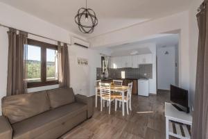 a living room with a couch and a table and a kitchen at Mariettas Apartment in Alykes