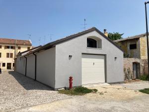 un garaje con una boca de incendios roja delante de él en AL RUDERINO, en Comacchio