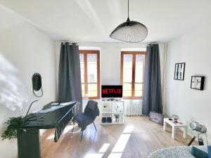 Televízia a/alebo spoločenská miestnosť v ubytovaní Le BarberShop, centre ville, parking gratuit
