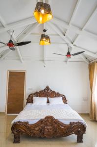 a bedroom with a large bed with two ceiling fans at Tinton Hillstay in Chikmagalūr