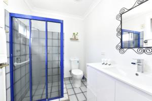 a bathroom with a glass shower door and a toilet at Sunshine Shores in Morisset East