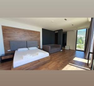 a bedroom with a large bed and a couch at Le Rêve Boutique Hotel in Dhërmi