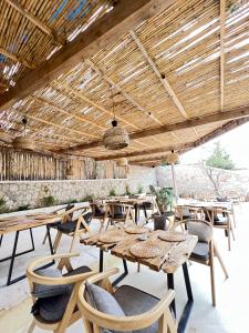 a restaurant with tables and chairs and a wooden ceiling at Le Rêve Boutique Hotel in Dhërmi