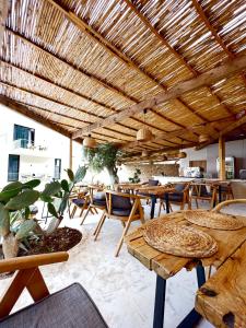 a patio with tables and chairs under a wooden roof at Le Rêve Boutique Hotel in Dhërmi