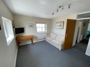 a living room with a couch and a television at Splashpoint with FREE parking in Worthing