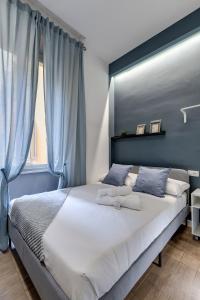 1 dormitorio con 1 cama grande y cortinas azules en COLLINA 24 SUITES - close to VIA VENETO, en Roma