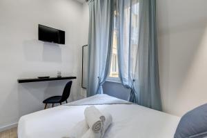 een slaapkamer met een bed met witte lakens en een raam bij COLLINA 24 SUITES - close to VIA VENETO in Rome