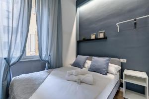 een kleine slaapkamer met een bed met blauwe muren bij COLLINA 24 SUITES - close to VIA VENETO in Rome