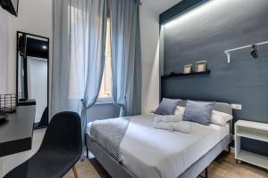1 dormitorio con cama, escritorio y silla en COLLINA 24 SUITES - close to VIA VENETO, en Roma
