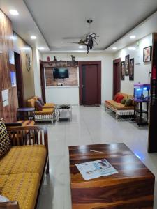 een woonkamer met banken en een tafel en een televisie bij Sakuntala Residency in Bhubaneshwar