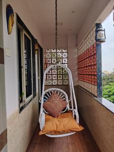 een witte stoel op een balkon met een kussen bij Sakuntala Residency in Bhubaneshwar