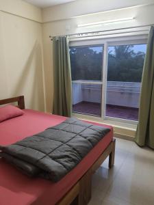 Castle JP Deluxe في بانغالور: غرفة نوم بسرير ونافذة كبيرة