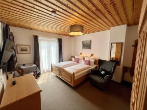 um quarto com uma cama, um sofá e uma cadeira em Haus Waltraud em Bad Wiessee